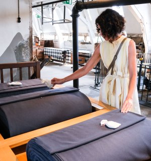 Ilona Marx examines the fabrics in the cloth factory, © Eva Sieben
