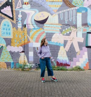Nina stands in front of a large mural in Cologne-Ehrenfeld, © Nina Hüpen-Bestendonk