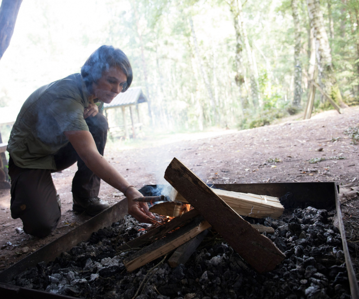Ranger Nina Braun looks after the campfire., © Ralph Sondermann, Tourismus NRW e.V.